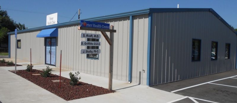 gray health center building with blue roof